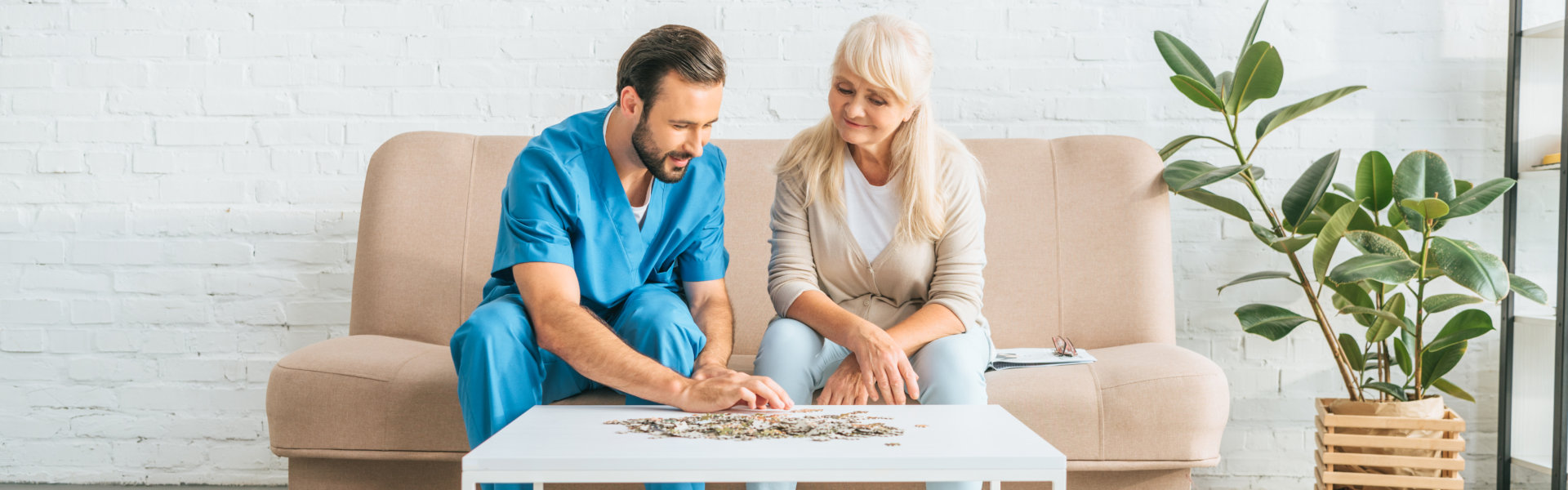 woman and young social worker playing with jigsaw puzzle